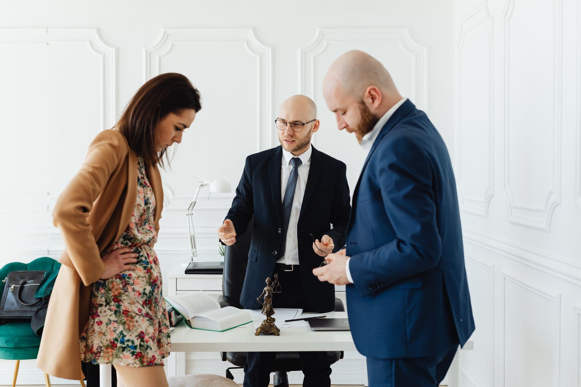 Dans un cabinet, avocats et clients discutent des honoraires liés au divorce.